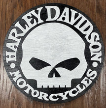 Load image into Gallery viewer, A circular Harley Motorcycles sign featuring a stylized skull in black and white, mounted on a dark wood background.