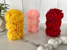 Load image into Gallery viewer, Bring timeless elegance and the warm glow of natural beeswax into your home with this handcrafted Rose Beeswax Pillar Candle. Beautifully sculpted with delicate rose petals, this stunning floral candle creates a cozy ambiance while showcasing the natural beauty of pure American beeswax.