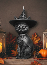 Load image into Gallery viewer, Celebrate the magic of Halloween with this enchanting Black Cat Beeswax Candle, handcrafted from 100% pure American beeswax. Featuring a charming black cat wearing a classic witch's hat adorned with a mystical triple moon symbol and skull centerpiece, this candle is the perfect accent for Halloween displays, gothic home décor, altars, and witchy spaces.