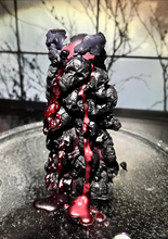Load image into Gallery viewer, Unleash the spooky vibe with our one-of-a-kind bleeding skull beeswax candle. As it burns, watch in awe as the 'blood' oozes and the skulls roll off onto the plate, adding an eerie touch to your Halloween decorations. The glowing eyes and piles of skulls and bones make this pillar candle a must-have for gothic and fall decor. Perfect for gifting to skull-loving friends or for adding a touch of horror to any room. Get yours now and bring the creepy factor to your home!