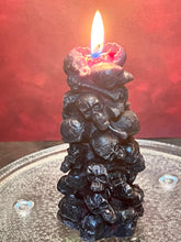 Load image into Gallery viewer, Unleash the spooky vibe with our one-of-a-kind bleeding skull beeswax candle. As it burns, watch in awe as the 'blood' oozes and the skulls roll off onto the plate, adding an eerie touch to your Halloween decorations. The glowing eyes and piles of skulls and bones make this pillar candle a must-have for gothic and fall decor. Perfect for gifting to skull-loving friends or for adding a touch of horror to any room. Get yours now and bring the creepy factor to your home!