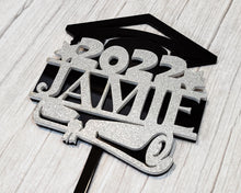 Load image into Gallery viewer, Make your graduation celebration even more special with this custom-made cake topper. Its personalized design with your student's name adds a thoughtful touch to any cake. A perfect way to commemorate this momentous occasion!