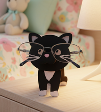 Load image into Gallery viewer, Keep your glasses easy to find with this adorable Cat Eyeglass Holder. Designed to hold your eyeglasses right across the cat's nose, this whimsical wooden glasses stand combines practical organization with cute cat décor.
Place your cat glasses holder on your nightstand, dresser, desk, or beside your favorite reading chair and give your eyeglasses their own special place when you're not wearing them.
