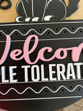 Load image into Gallery viewer, Let guests know exactly where they stand with this hilarious “Cats Welcome, People Tolerated” door hanger sign! Featuring an adorable black cat giving the ultimate snide side-eye look, this fun and sassy sign is the perfect addition to any cat lover’s home décor.