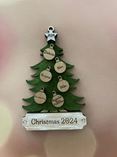 Load image into Gallery viewer, This beautiful Christmas Tree Personalized Ornament is sure to become a cherished, family favorite for years to come.  Add your loved ones and/or pets names to the ornaments on the tree to create a lasting keepsake.   Available in 3 different, hand painted styles and your choice of natural wood or colored ornaments.  Add a custom banner at the bottom to make it uniquely yours.  Please specify color of ornament and name when ordering.  