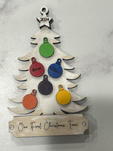 Load image into Gallery viewer, This beautiful Christmas Tree Personalized Ornament is sure to become a cherished, family favorite for years to come.  Add your loved ones and/or pets names to the ornaments on the tree to create a lasting keepsake.   Available in 3 different, hand painted styles and your choice of natural wood or colored ornaments.  Add a custom banner at the bottom to make it uniquely yours.  Please specify color of ornament and name when ordering.  