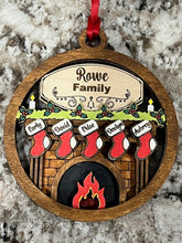 Load image into Gallery viewer, Our exquisite Fireplace Ornament with Personalized Stockings & Family Name on mantle – the perfect addition to your holiday décor that captures the essence of family warmth and festive joy. Transform your Christmas tree into a cherished symbol of togetherness with this beautifully crafted keepsake ornament.