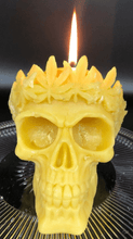 Load image into Gallery viewer, Large, Creepy, gothic skull beeswax candle with leaf crown.  Eyes glow when lit.  Halloween decor or gothic decor.