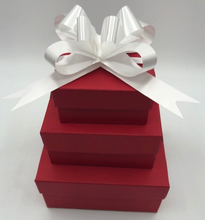 Load image into Gallery viewer, That special someone is sure to feel the love this Valentines Day when they open this fantastic Valentines Day Gift Box Trio.  A stack of 3 red boxes tied with a white ribbon.  Set contains 1 Red Beeswax Rose Pillar Candle, 1 Lavender Bath Bomb & 1 Heart Shaped Goat's Milk Soap in either Lavender or Rose Geranium scents.