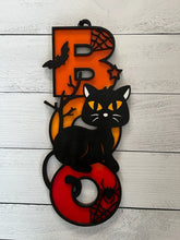 Load image into Gallery viewer, Light up your Halloween decor with this incredible Cat Boo sign.  The perfect addition to your spooky Halloween decor! This adorable black cat design is sure to charm your guest and add a playful touch to your home.  Featuring a whimsical black cat with bats and spider webs, this decorative piece sits atop the word "BOO" in bright orange, yellow and red, making it a vibrant and eye-catching accent for any space.