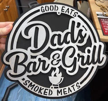 Load image into Gallery viewer, Surprise Dad this year with this Dad's Bar & Grill, Good Eats, Smoked Meats sign to help him show off his barbeque skills.  Hand made, laser cut design.   Approx. size 12" round