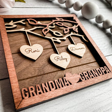Load image into Gallery viewer, Beautiful wood Family Tree sign with hearts hanging down from branches with your family's names on each heart. You can add up to 25 names to each frame. At the bottom, we offer over 100 different options for wording on these custom home decor signs. Happy Mother's Day, We (heart) Mom, Happy Father's Day, We (heart) Grandma and many more.