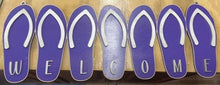 Load image into Gallery viewer, Add a bit of summer to your entry way with this Flip Flop Welcome Door Hanger Sign.  These adorable flip flops spelling out WELCOME invite guest into your home.  Perfect for lake houses, beach retreats or just to add a bit of summer decor.