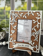 Load image into Gallery viewer, This Hummingbird Photo Frame is the perfect way to display your cherished memories with loved ones. This unique and personalized photo frame can be customized with up to 20 names in the hearts hung around the frame and custom wording in the banner across the bottom, making it a special and meaningful addition to any home decor. Available for a 4" x 6" or a 5" x 7" photo.