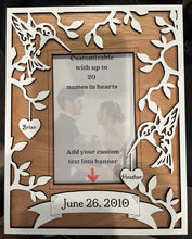 Load image into Gallery viewer, Beautiful Hummingbird layered photo frame with hearts hanging down that you have engraved with your family's names.  Hummingbirds & a tree design decorate the outside border of this frame in white, with a cherry wood background.  The frame can also have a custom banner added at the bottom with a date, family name, or a quote.  The perfect gift for weddings, anniversaries, baby showers, or birthdays.  Personalize with up to 20 different names.