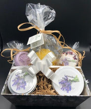 Load image into Gallery viewer, Lavender themed gift basket all ready to deliver to your loved ones. Basket includes a body butter, a lotion bar, a bath bomb, an all natural beeswax candle (unscented) & a soap bar. An additional body butter or bath product can be substituted for the candle. Handmade in the USA.