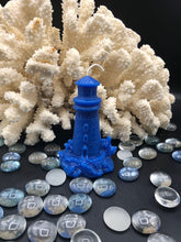 Load image into Gallery viewer, This Lighthouse beeswax candle takes you back to the sea & promises to bring images of the seashore to your dreams.  Perfect for nautical or coastal themed decor or as a gift to the beach lover in your life.  Allow this stunning candle to envelop your room in a warm glow with a sweet honey aroma.  Shown in blue.  Also available in natural yellow beeswax.