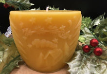 Load image into Gallery viewer, Oval all natural beeswax candle with Santa and his reindeer flying over a house in the woods. Pine tree design adorns the edges of the candle. Handmade in the USA.