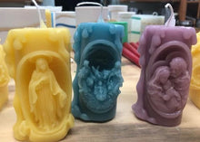 Load image into Gallery viewer, These beautifully detailed Religious Candles depict four different bible scenes - Jesus on the cross, the Virgin Mary, the Holy Family & the Nativity manger scene.  Bring the spirit of Christ into your home with these gorgeous beeswax candles.  They make fantastic gifts, are great for Christmas decor, housewarming gifts, holiday centerpieces and alters.  Available in purple, blue or natural yellow beeswax.