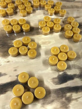 Load image into Gallery viewer, Timeless, classic tealight candles. With a long burn time, you can illuminate any space you'd like with the warm glow of these adorable candles. These make great gifts or souvenirs, especially for any nature lovers that you know. These are completely beeswax, nothing added. Your package will burst with a delicious explosion of warm and sweet honey scent as soon as you open it.  Great for use in worship, prayer, meditation, at an alter, rituals, showers, weddings or just to pamper yourself.