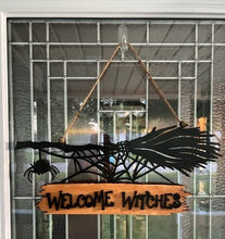 Load image into Gallery viewer, Welcome all the Witches to your home with this Welcome Witches broom sign.  A creepy little spider hangs off the end to add an extra bit of Halloween fun.