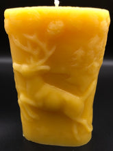 Load image into Gallery viewer, This two sided oval candle depicts a dear in a pine forest jumping on one side and a bear in the forest on the opposite side. The edges of this oval candle are adorned with a pine tree design. Handmade in the USA.