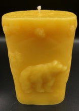 Load image into Gallery viewer, This two sided oval candle depicts a dear in a pine forest jumping on one side and a bear in the forest on the opposite side. The edges of this oval candle are adorned with a pine tree design. Handmade in the USA.