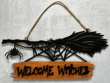 Load image into Gallery viewer, Welcome all the Witches to your home with this Welcome Witches broom sign. A creepy little spider hangs off the end to add an extra bit of Halloween fun. Great for Halloween Parties, gifts for the Halloween lovers in your life or to spruce up your Halloween decor. Witch broom on top with a creeping spider hanging off the side & a spider web below. Wood sign attached to the bottom reads 'Witches Welcome'.