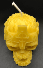 Load image into Gallery viewer, Creepy, ornate skull beeswax candle with cross crown.  Eyes glow after it starts to burn down.  Top view.