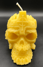 Load image into Gallery viewer, Creepy, ornate skull beeswax candle with cross crown.  Eyes glow after it starts to burn down.