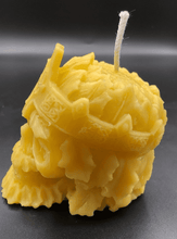 Load image into Gallery viewer, Creepy, ornate skull beeswax candle with cross crown.  Eyes glow after it starts to burn down.  Side view.