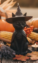 Load image into Gallery viewer, Celebrate the magic of Halloween with this enchanting Black Cat Beeswax Candle, handcrafted from 100% pure American beeswax. Featuring a charming black cat wearing a classic witch's hat adorned with a mystical triple moon symbol and skull centerpiece, this candle is the perfect accent for Halloween displays, gothic home décor, altars, and witchy spaces.
