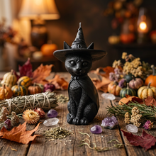 Load image into Gallery viewer, Celebrate the magic of Halloween with this enchanting Black Cat Beeswax Candle, handcrafted from 100% pure American beeswax. Featuring a charming black cat wearing a classic witch's hat adorned with a mystical triple moon symbol and skull centerpiece, this candle is the perfect accent for Halloween displays, gothic home décor, altars, and witchy spaces.
