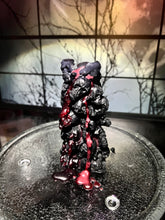 Load image into Gallery viewer, Unleash the spooky vibe with our one-of-a-kind bleeding skull beeswax candle. As it burns, watch in awe as the 'blood' oozes and the skulls roll off onto the plate, adding an eerie touch to your Halloween decorations. The glowing eyes and piles of skulls and bones make this pillar candle a must-have for gothic and fall decor. Perfect for gifting to skull-loving friends or for adding a touch of horror to any room. Get yours now and bring the creepy factor to your home!
