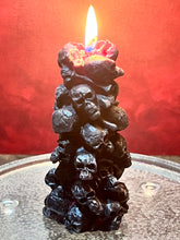 Load image into Gallery viewer, Unleash the spooky vibe with our one-of-a-kind bleeding skull beeswax candle. As it burns, watch in awe as the 'blood' oozes and the skulls roll off onto the plate, adding an eerie touch to your Halloween decorations. The glowing eyes and piles of skulls and bones make this pillar candle a must-have for gothic and fall decor. Perfect for gifting to skull-loving friends or for adding a touch of horror to any room. Get yours now and bring the creepy factor to your home!
