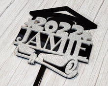 Load image into Gallery viewer, Make your graduation celebration even more special with this custom-made cake topper. Its personalized design with your student&#39;s name adds a thoughtful touch to any cake. A perfect way to commemorate this momentous occasion!
