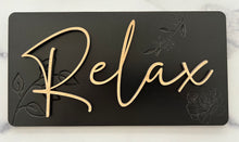 Load image into Gallery viewer, Transform your bathroom into a serene oasis with these Beautiful Relax, Soak, Unwind signs. Crafted from high-quality wood, each sign features delicate embossing of subtle flowers and foliage, creating a soft, nature-inspired background. Perfectly sized at 11 1/2” long x 6” tall, these signs effortlessly add a calming spa-like touch to any space. Whether you&#39;re creating a tranquil retreat or enhancing your bathroom&#39;s décor, these elegant signs bring a sense of peace and relaxation to your home.
