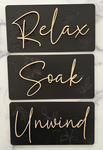 Transform your bathroom into a serene oasis with these Beautiful Relax, Soak, Unwind signs. Crafted from high-quality wood, each sign features delicate embossing of subtle flowers and foliage, creating a soft, nature-inspired background. Perfectly sized at 11 1/2” long x 6” tall, these signs effortlessly add a calming spa-like touch to any space. Whether you're creating a tranquil retreat or enhancing your bathroom's décor, these elegant signs bring a sense of peace and relaxation to your home.