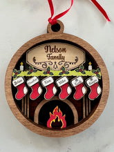 Load image into Gallery viewer, Celebrate everyone who makes your house a home with this beautiful Personalized Family Christmas Ornament. Featuring a cozy fireplace scene, personalized stockings, and your family name on the mantel, this hand-painted keepsake is a special way to celebrate your family at Christmas.
