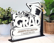 Load image into Gallery viewer, This Graduation Tassel Holder is the perfect way to commemorate your special event. It is designed to securely hold your tassel in place and is personalized with your name, graduation year or a personalized message. Show off your style and pride with a custom made holder that you can use to display your graduation tassel.  Available in 2023, 2024, 2025 and 2026 styles.  
