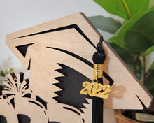 Load image into Gallery viewer, This Graduation Tassel Holder is the perfect way to commemorate your special event. It is designed to securely hold your tassel in place and is personalized with your name, graduation year or a personalized message. Show off your style and pride with a custom made holder that you can use to display your graduation tassel.  Available in 2023, 2024, 2025 and 2026 styles.  Slot for tassel.

