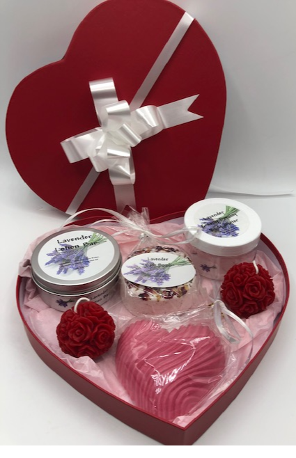 Unique Valentines Day Gift in red, heart shaped gift box. Set includes 1 Lavender Body Butter, 1 Lavender Lotion Bar, 1 Lavender Bath Bomb, 1 Lavender or Rose Geranium scented Heart Shaped Goat's Milk Soap & 2 Beeswax Red Rose Ball Candles. Perfect for Valentines Day Gifts!