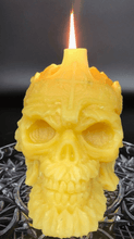 Load image into Gallery viewer, Creepy, ornate skull beeswax candle with cross crown.  Eyes glow after it starts to burn down.
