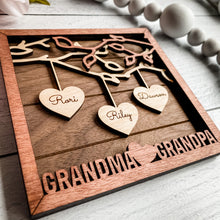 Load image into Gallery viewer, Beautiful wood Family Tree sign with hearts hanging down from branches with your family&#39;s names on each heart. You can add up to 25 names to each frame. At the bottom, we offer over 100 different options for wording on these custom home decor signs. Happy Mother&#39;s Day, We (heart) Mom, Happy Father&#39;s Day, We (heart) Grandma and many more.
