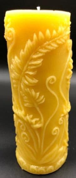 Elegant all natural beeswax pillar candle with fern leaves and fiddleheads adorning the sides. Handmade in the USA.