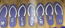 Load image into Gallery viewer, Add a bit of summer to your entry way with this Flip Flop Welcome Door Hanger Sign.  These adorable flip flops spelling out WELCOME invite guest into your home.  Perfect for lake houses, beach retreats or just to add a bit of summer decor.  
