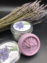 Load image into Gallery viewer, Purple round bar of lotion with lavender bouquet design in the middle. 3.5 oz approx. weight. These handy lotion bars are great when you&#39;re on the go or for everyday use! Natural body heat slightly melts a bit of the lotion onto your hands. Great for elbows and dry areas. It leaves your skin feeling smooth and hydrated. The beeswax adds a barrier of protection that keeps the lotion where you put it longer. Made by hand in the USA.
