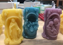 Load image into Gallery viewer, These beautifully detailed Religious Candles depict four different bible scenes - Jesus on the cross, the Virgin Mary, the Holy Family &amp; the Nativity manger scene.  Bring the spirit of Christ into your home with these gorgeous beeswax candles.  They make fantastic gifts, are great for Christmas decor, housewarming gifts, holiday centerpieces and alters.  Available in purple, blue or natural yellow beeswax.
