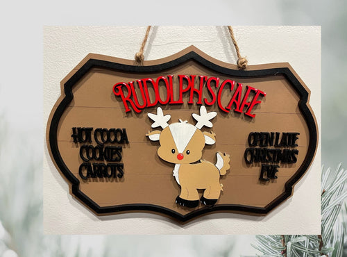 Give your decor a festive twist with this Rudolph's Cafe sign.  This adorable sign adds a touch of whimsey to any coffee bar or kitchen area offering Hot Cocoa, Cookies, and Carrots & adds that you're Open Late Christmas Eve.