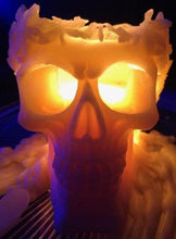 Load image into Gallery viewer, Large, Creepy, gothic skull beeswax candle with leaf crown. Eyes glow when lit. Halloween decor or gothic decor.  Eyes glowing on skull candle after about 45 hours of burn time.
